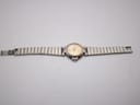 Dunhill watch with two-tone bracelet laid flat, showing the gold sunburst dial.