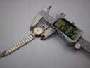 Digital caliper measuring the Dunhill watch case diameter at 28.16 mm.