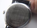 Tilted close-up of the brushed stainless steel case back, with 'Movado swiss quartz' and the model reference number clearly visible.