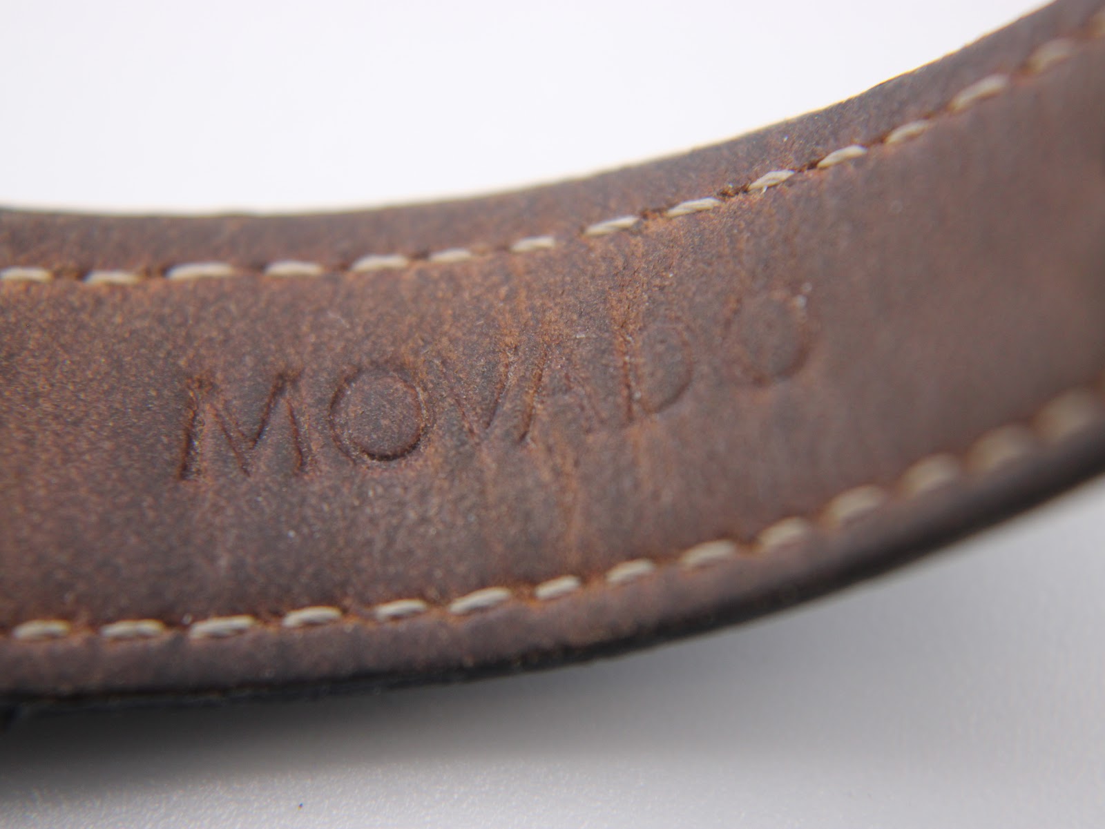 Close-up of the brown inner side of the black leather strap, clearly showing the debossed 'MOVADO' branding.