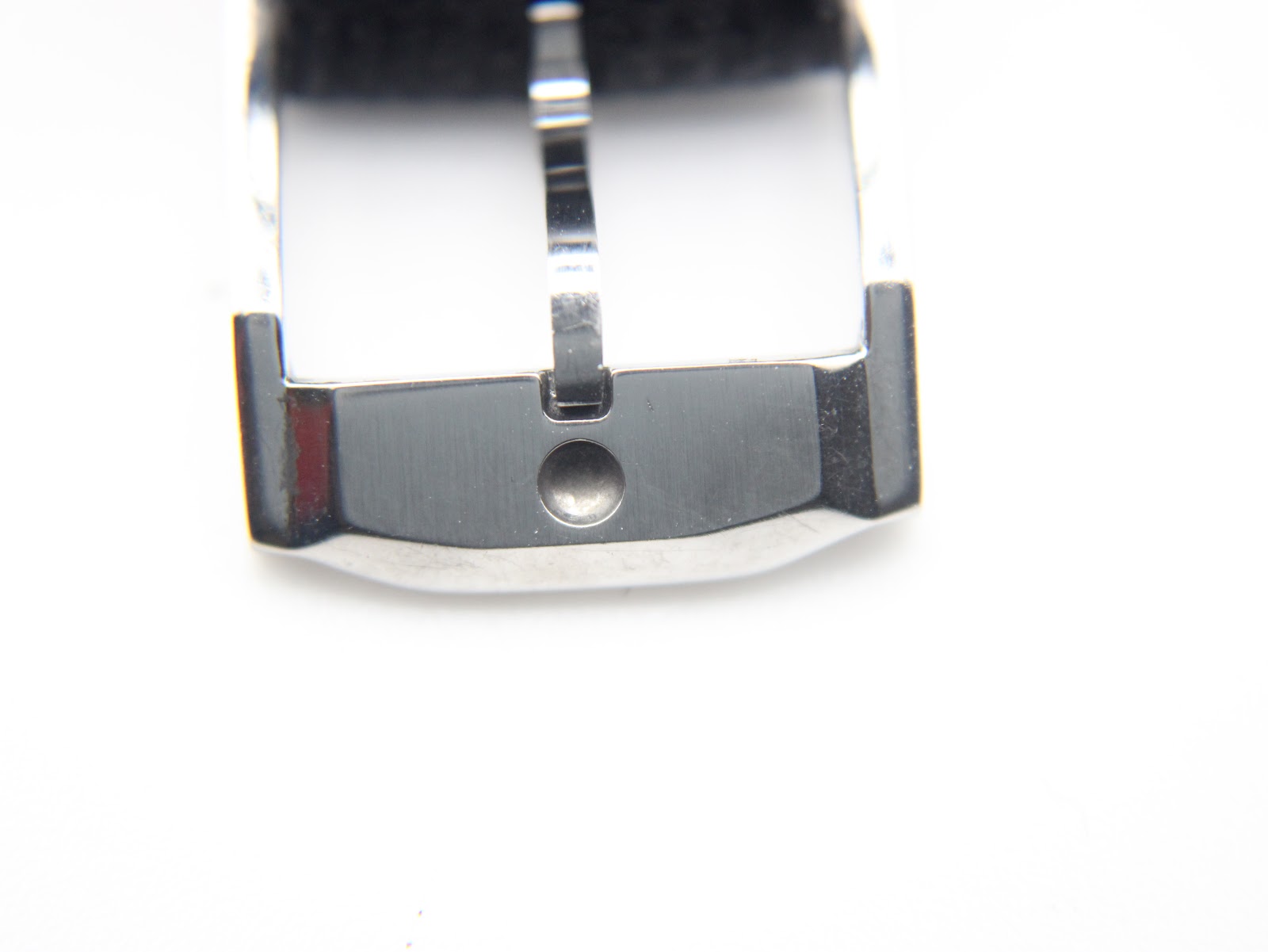 Close-up of the polished silver-tone pin buckle on the black leather strap against a white background.