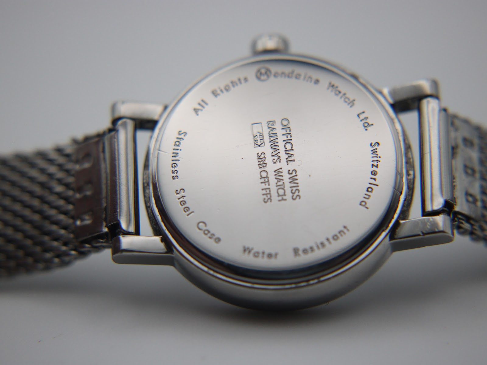 Close-up of the polished stainless steel case back with "Official Swiss Railways Watch" engraving.