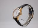 Angled side view of the Tissot watch on a display stand, showing the gold-tone case and signed Tissot crown.