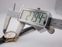 Digital caliper measuring the watch case diameter, displaying 27.94 mm.