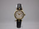 Front view of the Gucci 2000L ladies watch, showing the gold-tone case, cream textured dial with Roman numerals, and black leather strap.