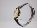 Right side profile of the Gucci 2000L watch, highlighting the gold-tone case, black side detailing, and signed Gucci crown.