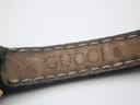 Close-up of the inside of the black leather strap, showing the embossed 'GUCCI' branding.