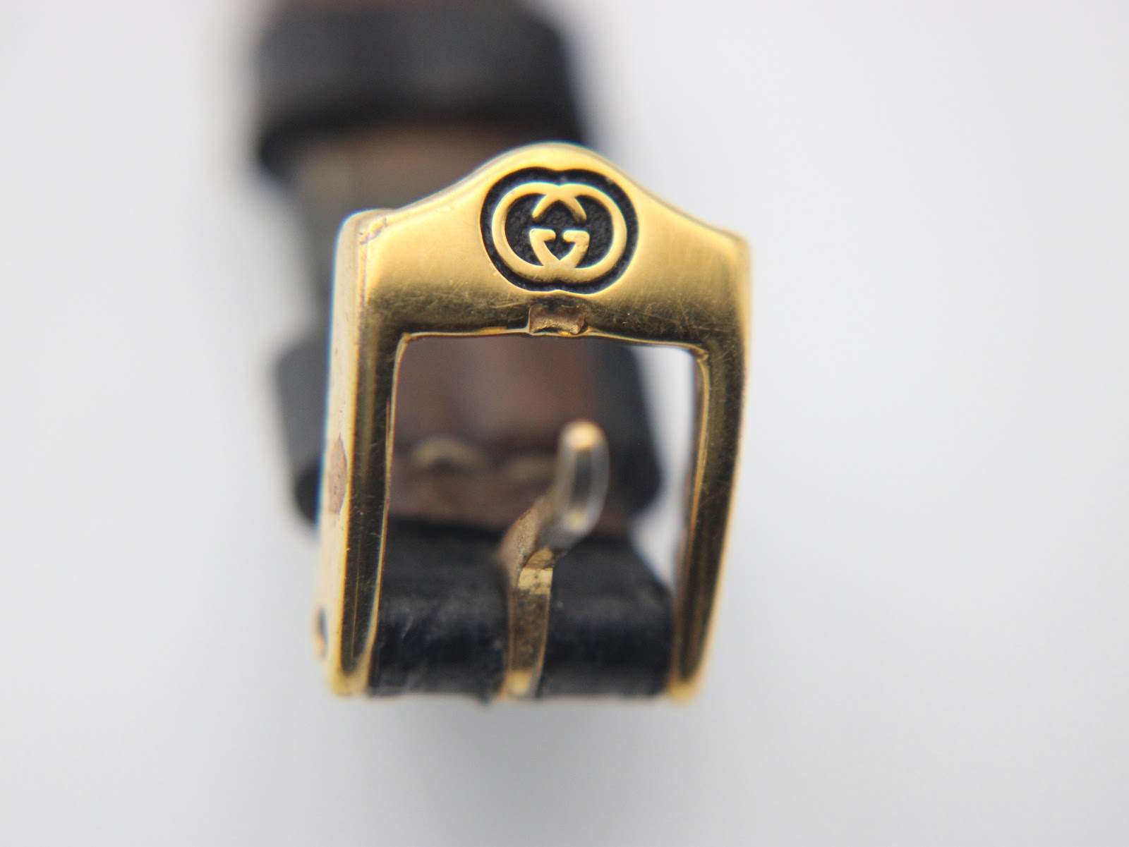 Front view of the original gold-tone Gucci buckle with the iconic interlocking G logo.