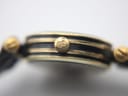 Detailed close-up of the gold-tone crown, clearly showing the embossed Gucci logo.