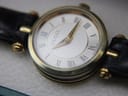 Angled close-up of the Gucci 2000L dial, revealing the cream textured finish, black Roman numerals, and gold-tone hands.