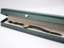 The Gucci 2000L watch presented in a green hinged display box with a crown motif, resting on a light-coloured interior.