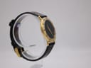 Opposite angled side view of the Gucci 3000.2.M watch, highlighting the case profile and black leather strap on a clear display stand.