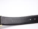 Close-up of the interior of the black leather strap, clearly showing the embossed 'GUCCI' branding.