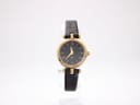 Front view of the Gucci 2000L watch on a stand, showing the black dial with gold Roman numerals and a black leather strap.