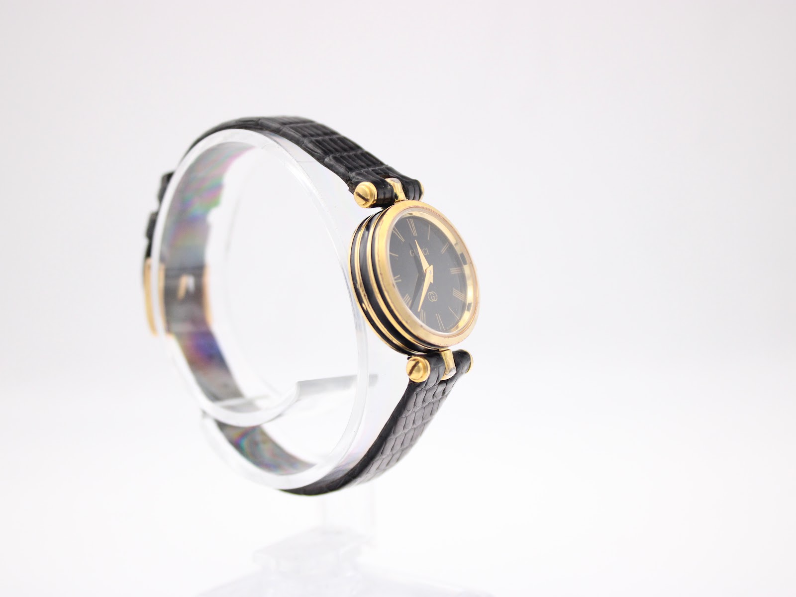 Another angled side view of the Gucci 2000L watch on a stand, showing the case profile and black leather strap.