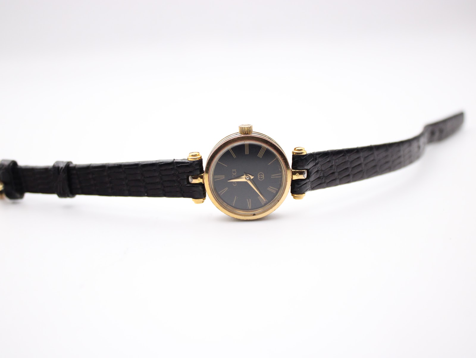 Top-down view of the Gucci 2000L watch with the black leather strap extended flat, showcasing the dial and case.