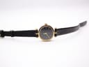 Top-down view of the Gucci 2000L watch with the black leather strap extended flat, showcasing the dial and case.