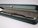 The Gucci 2000L watch resting inside a dark green presentation box with a cream interior.