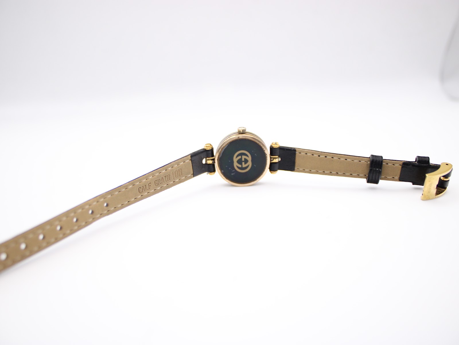 View of the watch from above, showing the back of the case and the black leather strap with 'calf grain' visible.