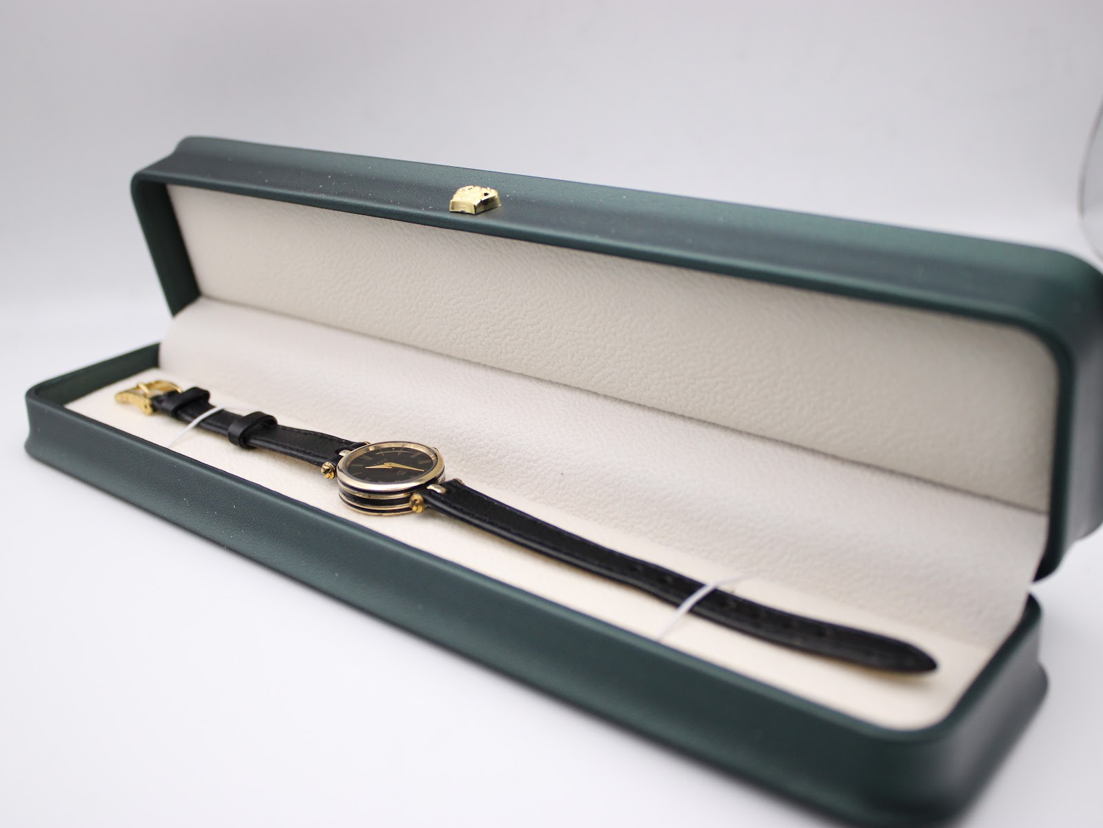 The Gucci 2000L watch presented inside a dark green watch box with a cream interior.