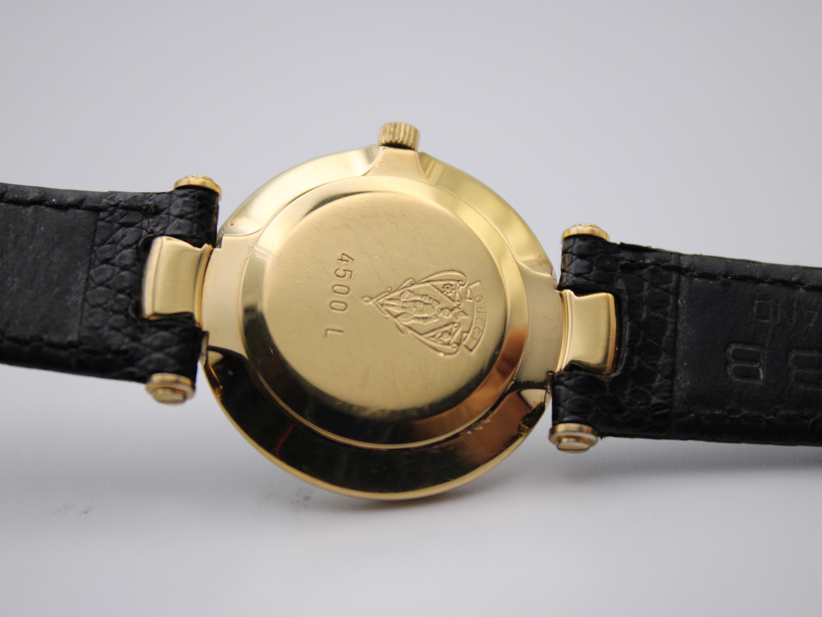 Close-up of the gold-tone case back of the Gucci 4500L, engraved with the model number '4500 L' and Gucci crest.