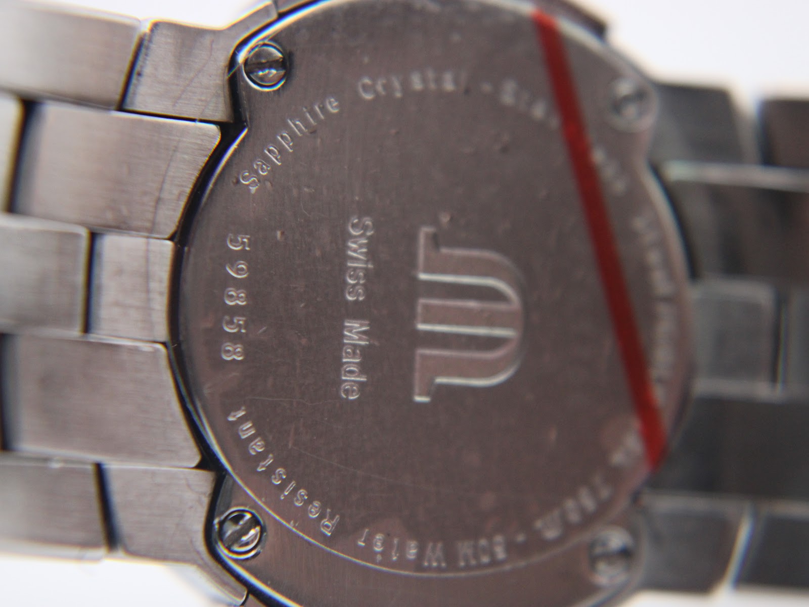 Close-up of the brushed stainless steel case back, showing 'Maurice Lacroix', 'Swiss Made', '59858', 'Sapphire Crystal', and '50m Water Resistant' engravings.
