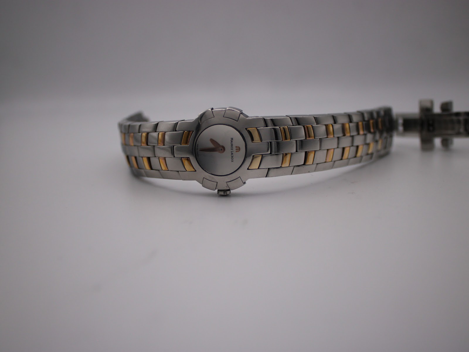 Full length view of the Maurice Lacroix watch, laid flat, showcasing the entire two-tone bracelet.