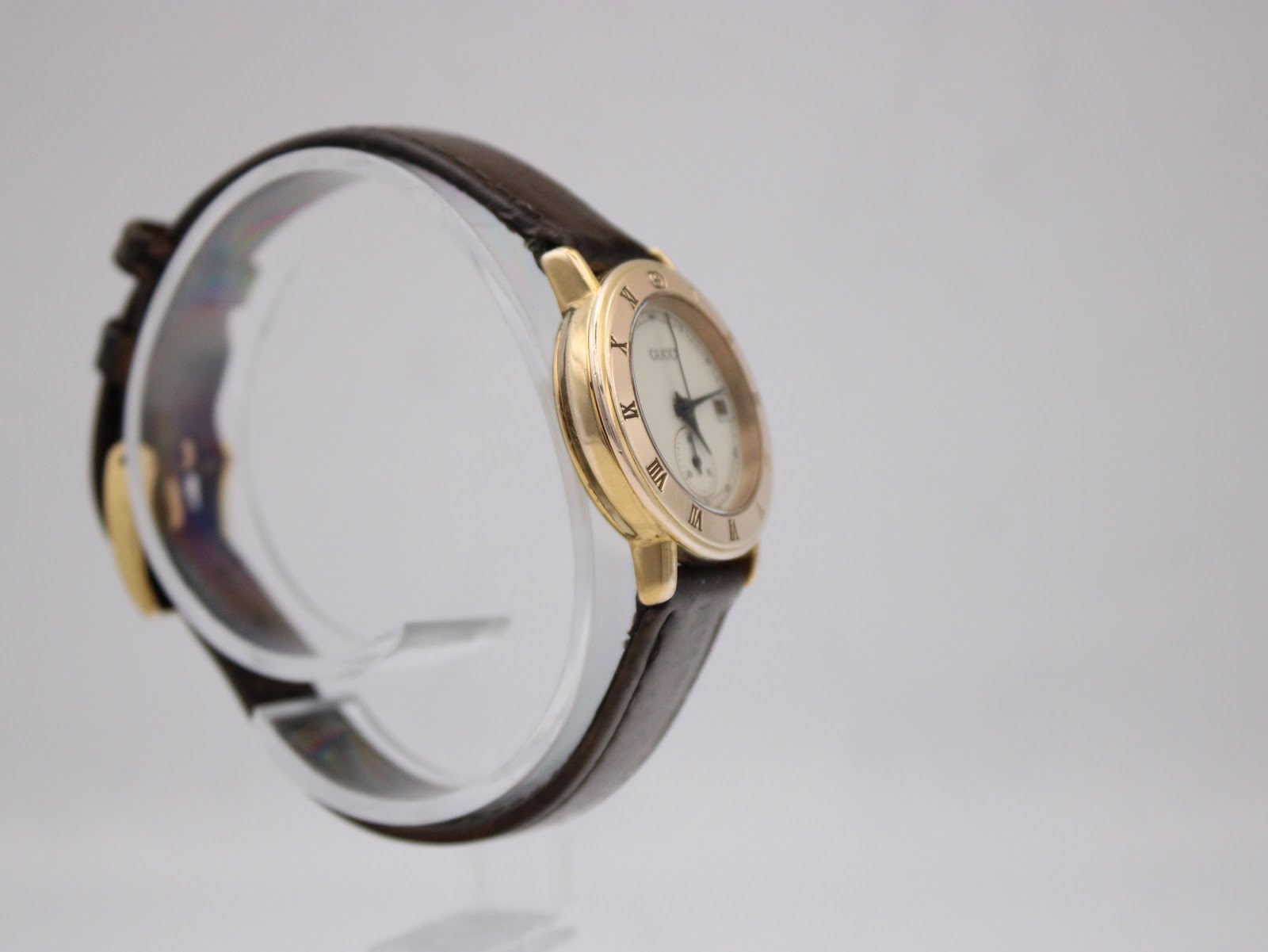 Another angled side view of the Gucci 3800L watch on a display stand, highlighting the case design.