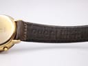 Close-up of the underside of the brown leather strap, showing 'GUCCI GENUINE LEATHER' embossed text.