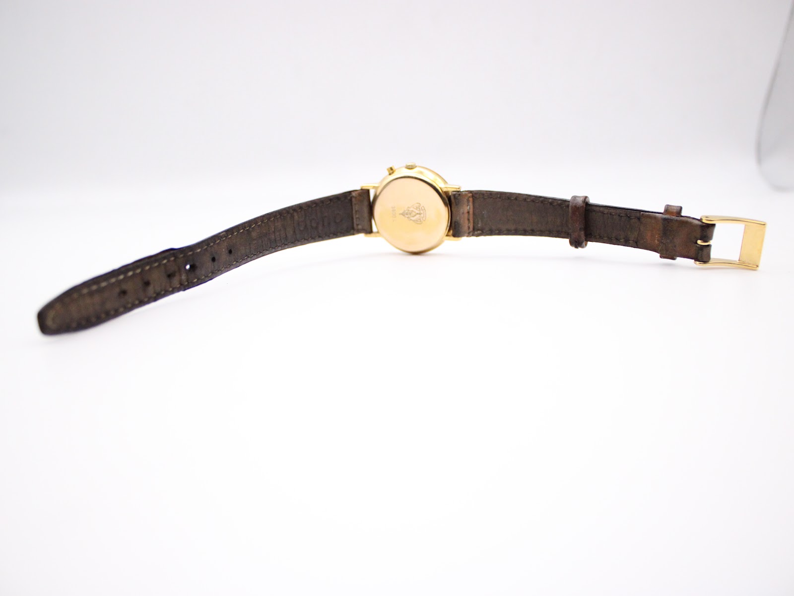 Full view of the Gucci 3800L watch from the back, with the brown leather strap fully extended and the signed buckle.