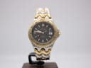Front view of the Ellesse two-tone diver watch on a stand, showing the black dial and gold-tone bezel.