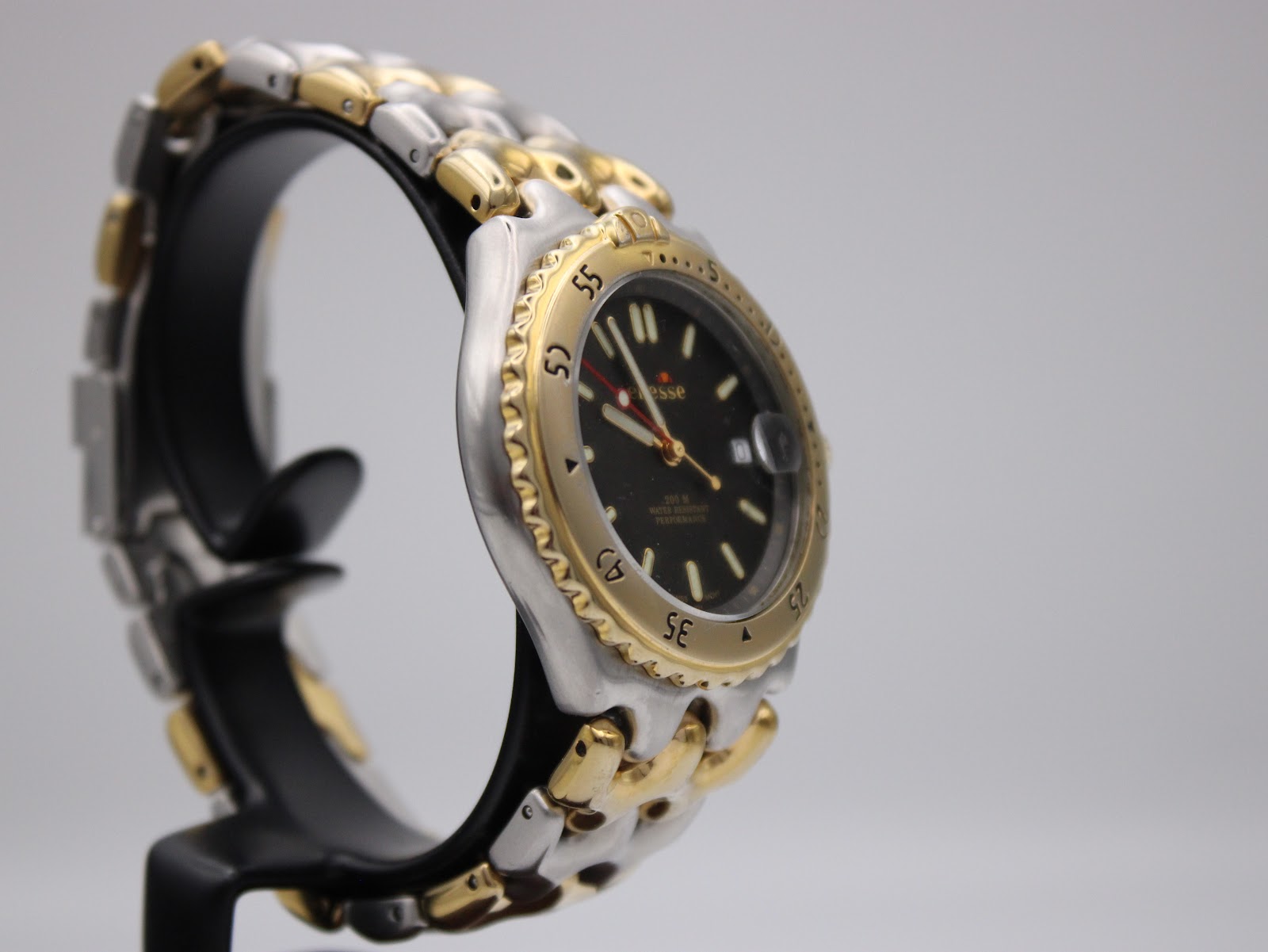 Left side view of the Ellesse watch on a stand, showing the curved case profile and bracelet links.