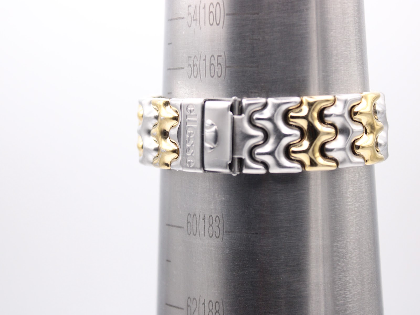 The two-tone bracelet on a wrist sizing gauge, indicating a fit of approximately 170-175mm.