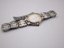 Overhead view of the Maurice Lacroix bi-colour watch with its distinctive bracelet laid flat, showing the white dial and gold details.