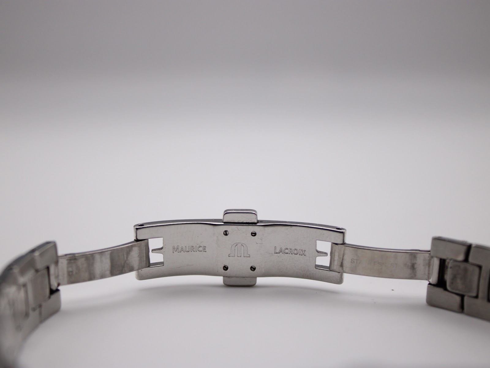 Close-up of the open clasp, showing "MAURICE LACROIX" logo and brand name engraved on the inner side of the steel.