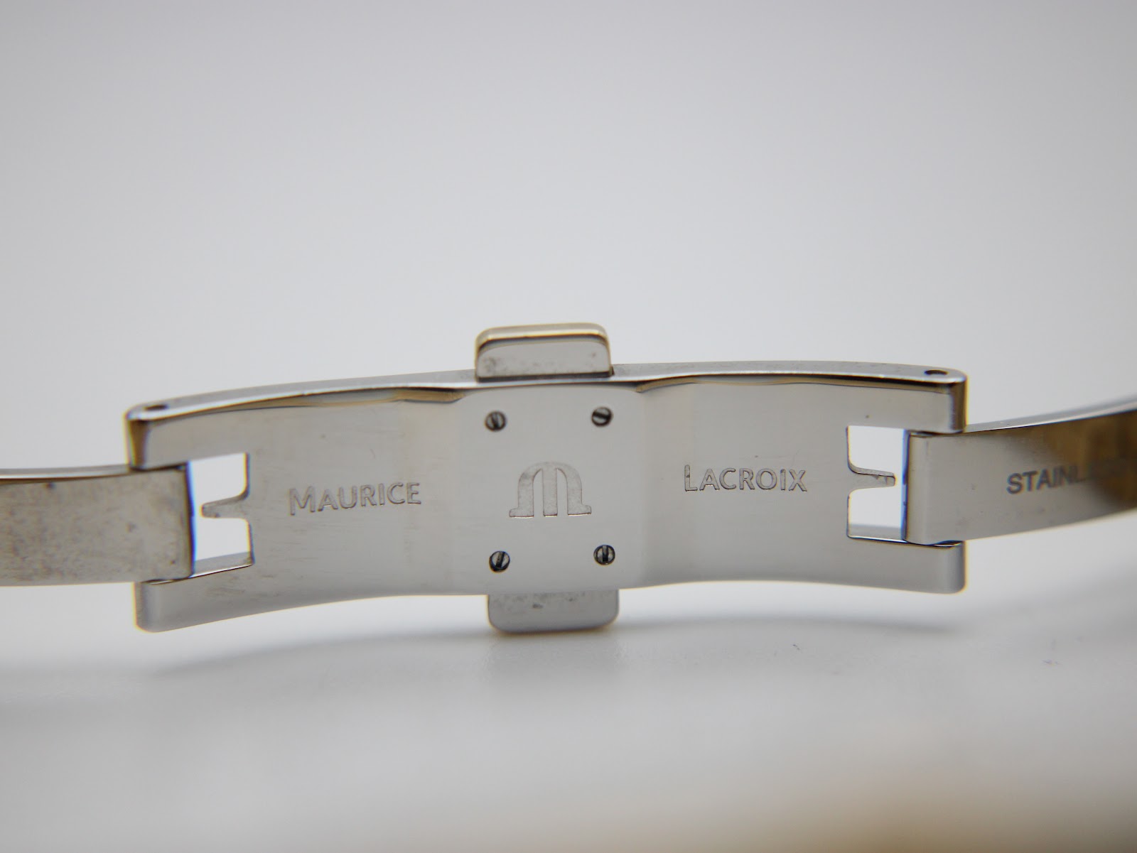 Close-up of the inside of the Maurice Lacroix gold-plated stainless steel folding clasp, showing the 'Maurice Lacroix' signature and logo.