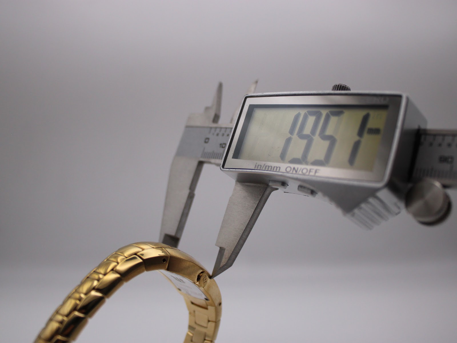 A digital caliper measuring the case width of the Maurice Lacroix watch, displaying a precise measurement of 19.51mm.