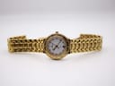 Full front view of the gold-tone Maurice Lacroix watch with its bracelet extended flat on a white surface.