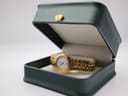 Maurice Lacroix watch resting in an open dark green presentation box with a cream-coloured interior.