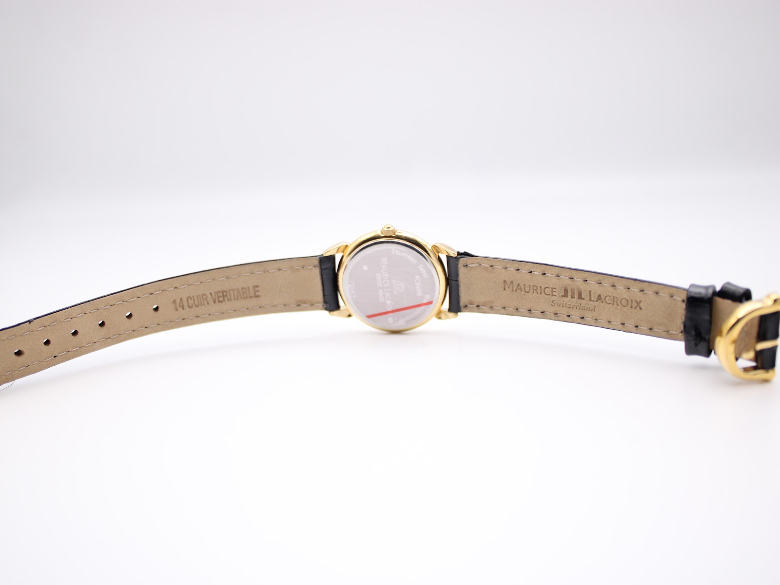 Underside view of the watch strap laid flat, showing "14 CUIR VERITABLE" and "MAURICE LACROIX Switzerland" printed on the black leather lining.