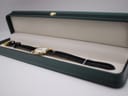 The Maurice Lacroix watch lying inside a dark green presentation box with a cream interior.