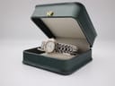 The Maurice Lacroix watch resting in a generic dark green display box, with the lid open.
