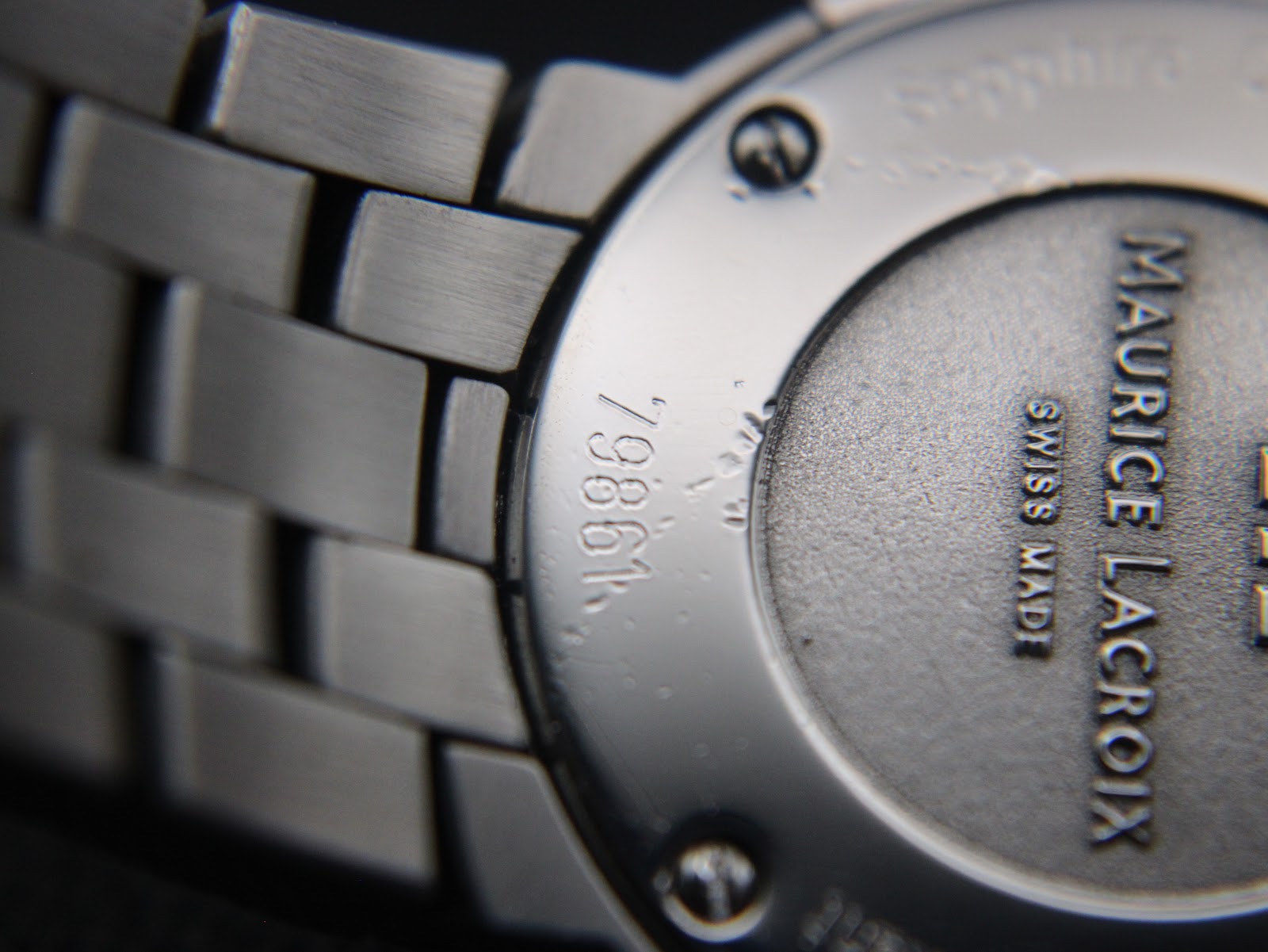 Angled close-up of the case back highlighting the model number '79861' and brushed finish of the bracelet links.