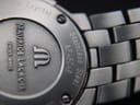 Angled close-up of the case back highlighting the serial number 'AF46049' and 'Stainless Steel' engraving.