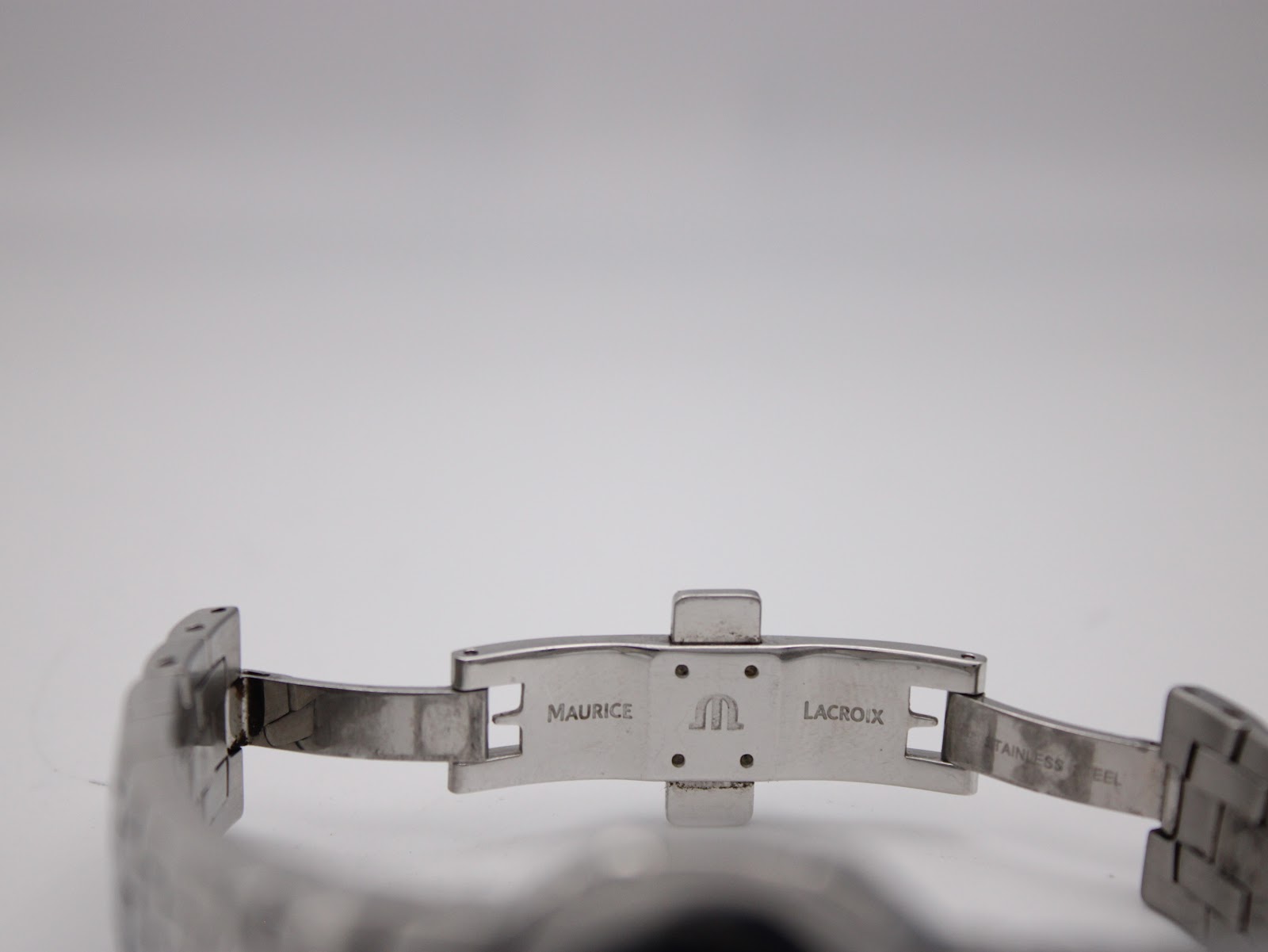 Close-up of the stainless steel deployment clasp, clearly signed with the Maurice Lacroix logo.
