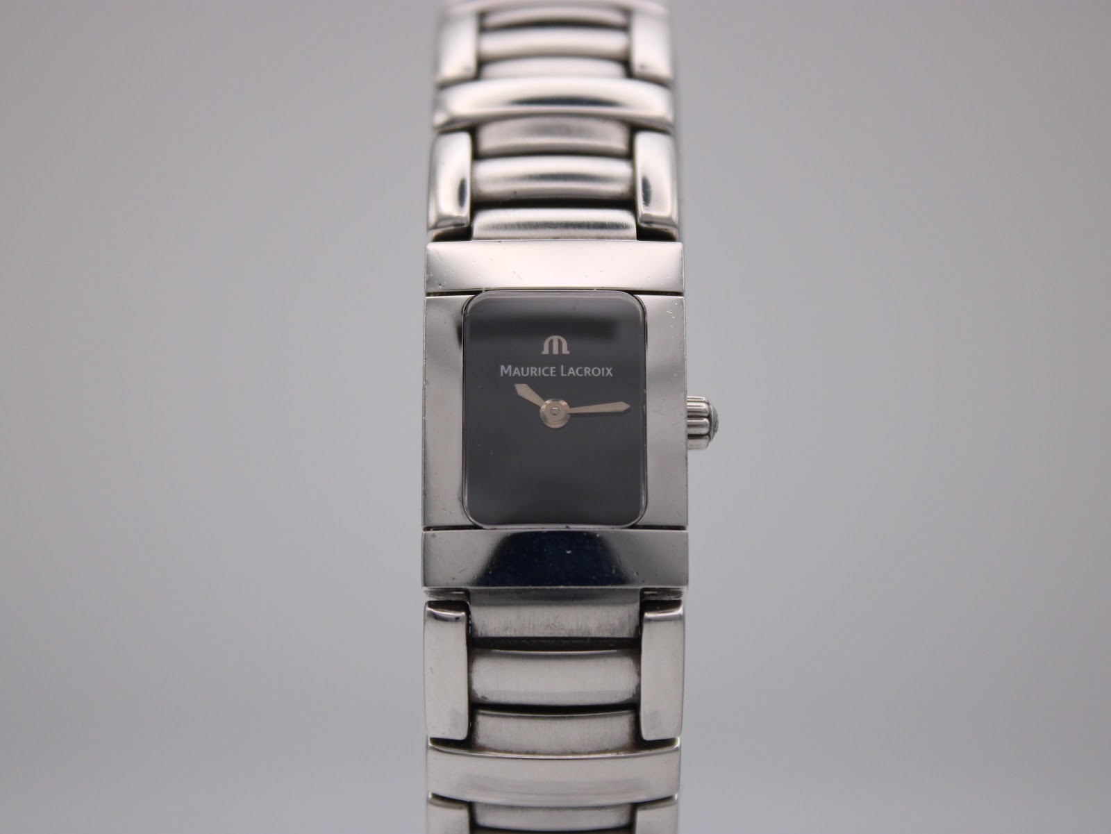 Slightly closer front view of Maurice Lacroix watch with rectangular black dial.