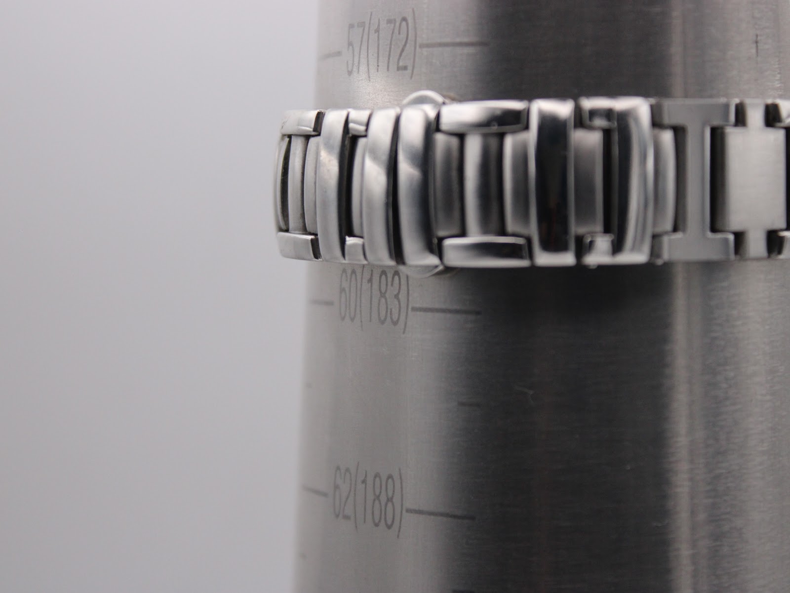 Close-up of the stainless steel bracelet on a wrist sizing gauge, indicating a wrist size of approximately 18.3cm.