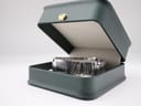 Maurice Lacroix watch resting in an open dark green presentation box with a cream interior.