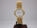 Front view of the Maurice Lacroix watch on a display stand, showing white dial, gold Arabic numerals, and gold electroplated bracelet.