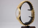 Side view of the Maurice Lacroix watch on a display stand, highlighting the profile of the gold electroplated case and bracelet.